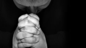 Man pray for something over black background with space for text on right