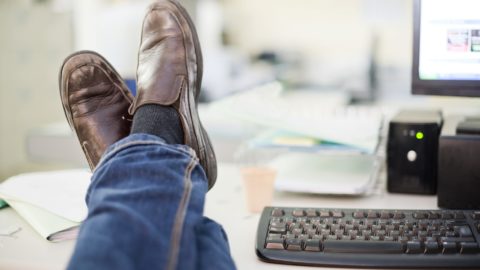 Resting at office: human legs on desk
