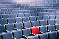 red chair in auditorium of blue chairs