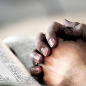 Hands folded on Bible